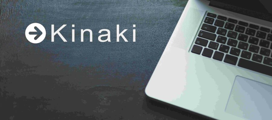 laptop on the old black wooden desk with Kinaki logo in background